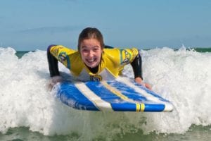Girls go surfing at Harlyn Surf School Padstow Cornwall UK